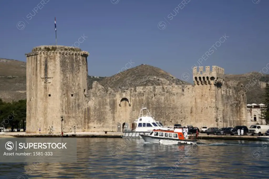 Motorboat in the sea in front of a fortress, Fortress Kamerlengo, Trogir, Croatia