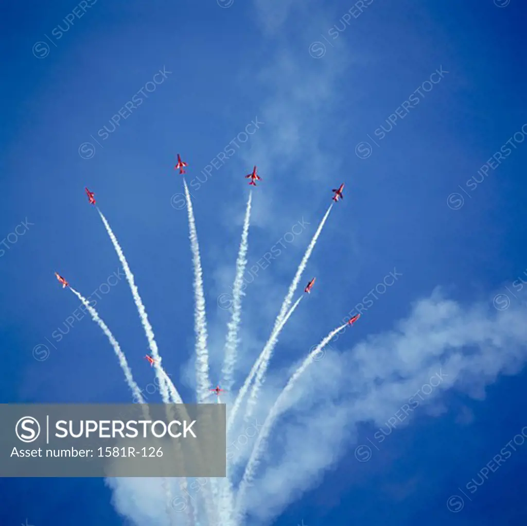 Low angle view of fighter planes performing aerobatics in sky, Red Arrows, Royal Air Force, England