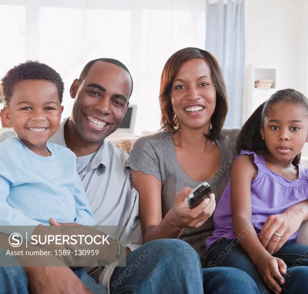 African American family watching television together