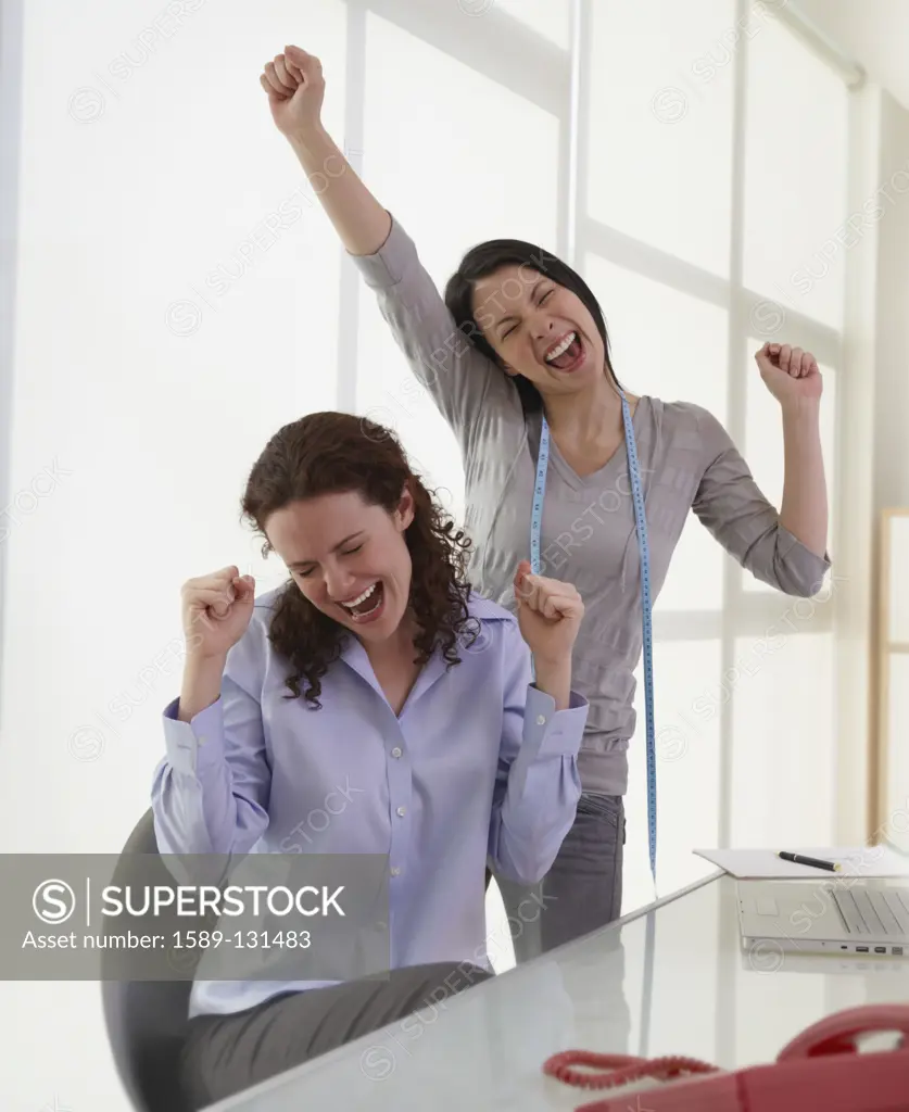 Businesswomen cheering in office