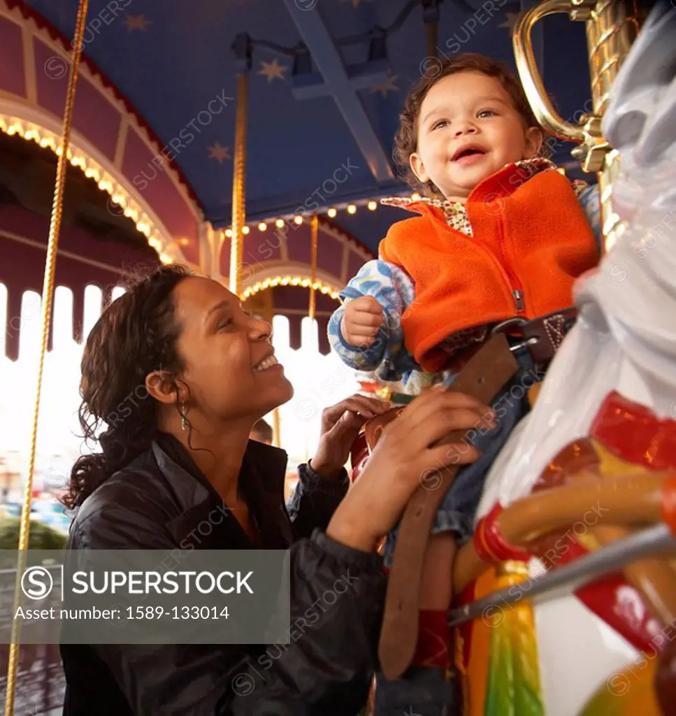 Mother and son enjoying carousel ride