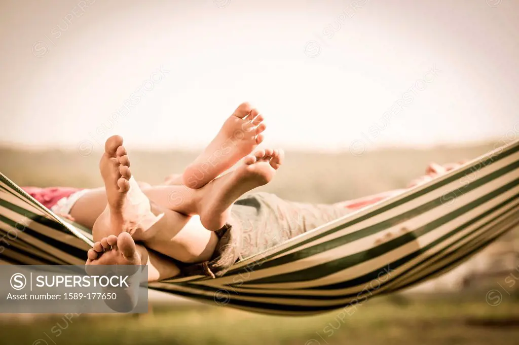 Mother and daughter relaxing in hammock outdoors