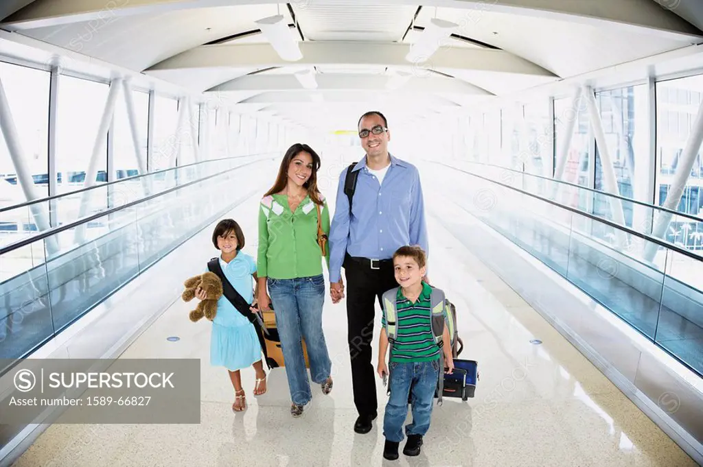 Hispanic family walking in airport