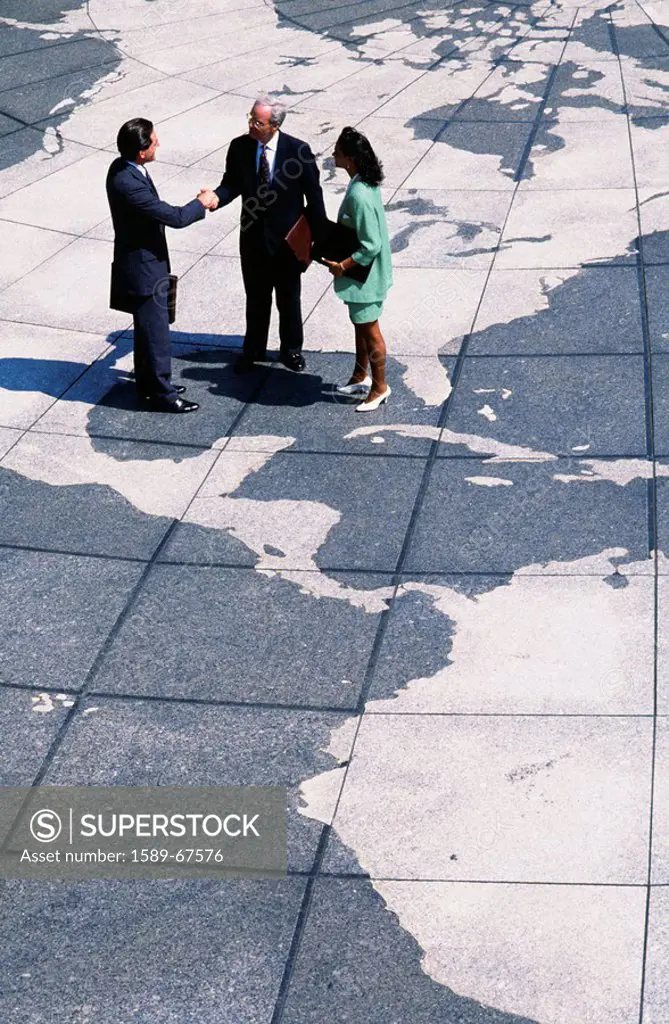 Businesspeople standing on map of globe