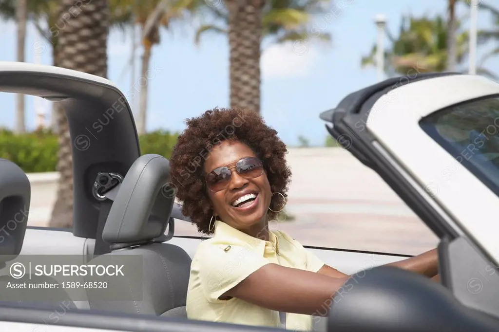 African American woman driving convertible
