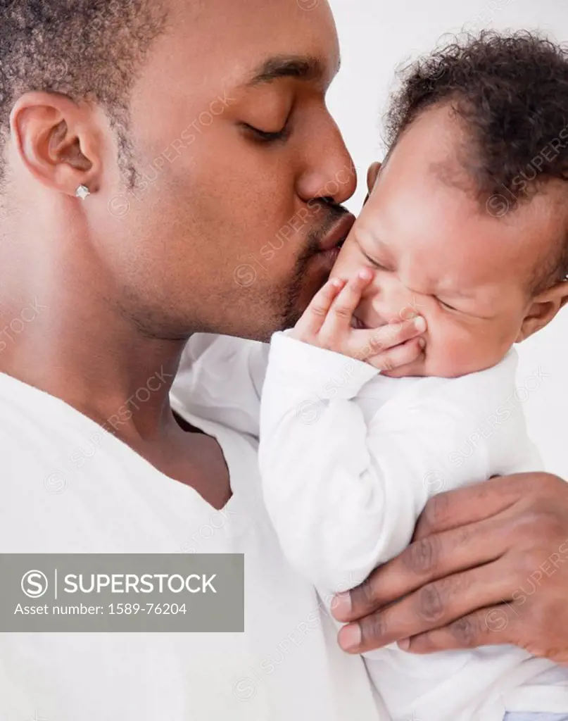 African man kissing baby