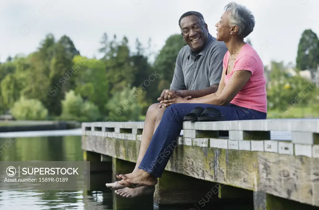 Elderly couple sitting together on a pier