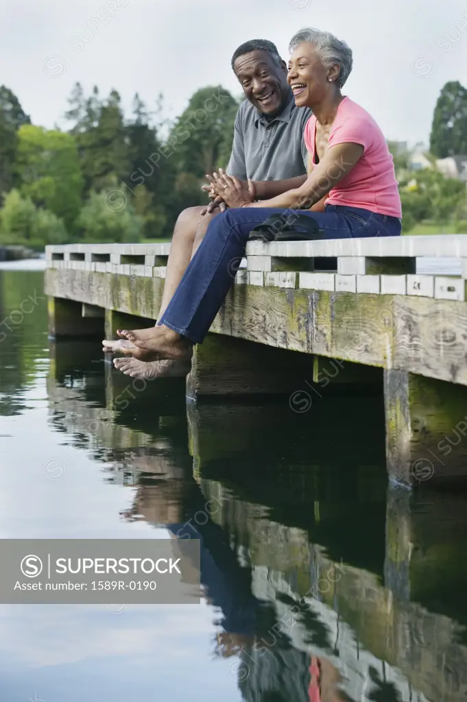 Elderly couple sitting together on a pier
