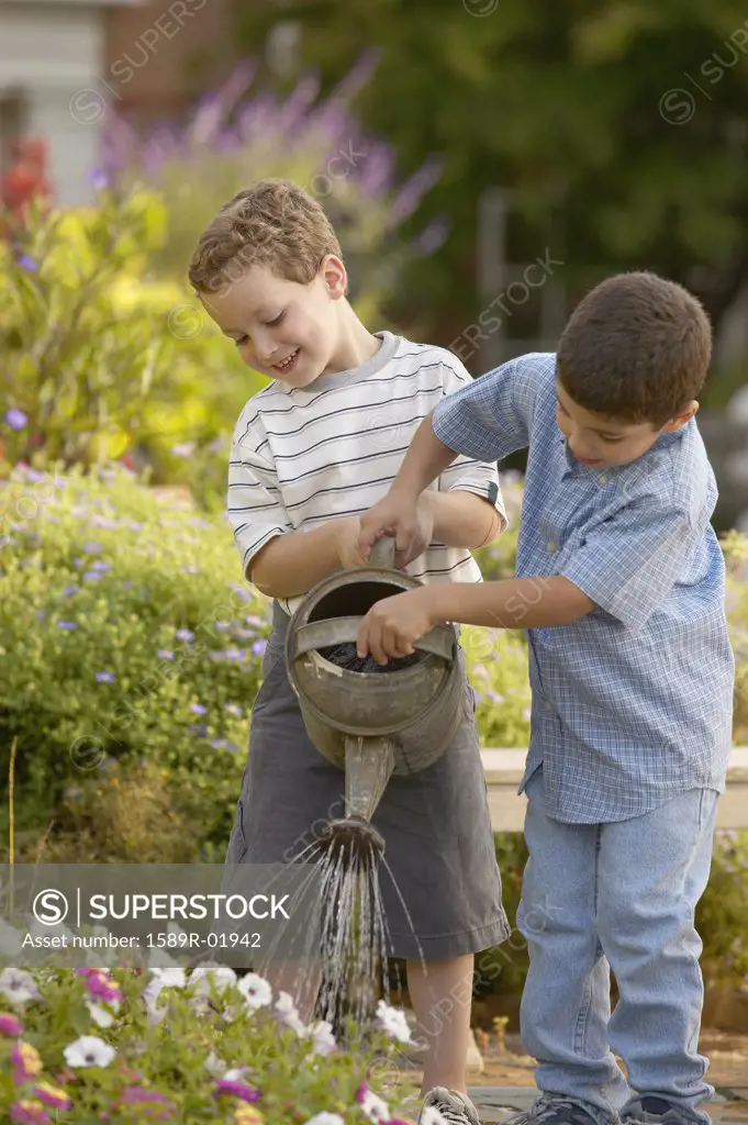 Two boys watering plants
