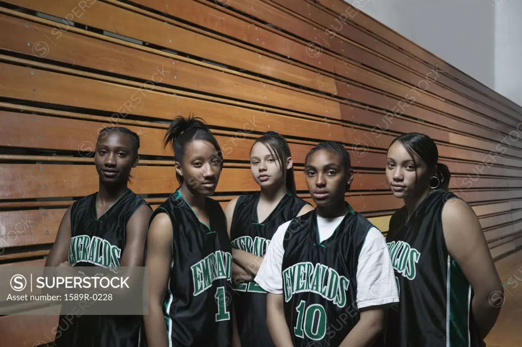A team of female teenage basketball players on a basketball court