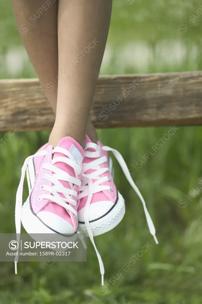 Legs of a child dangling from a fence