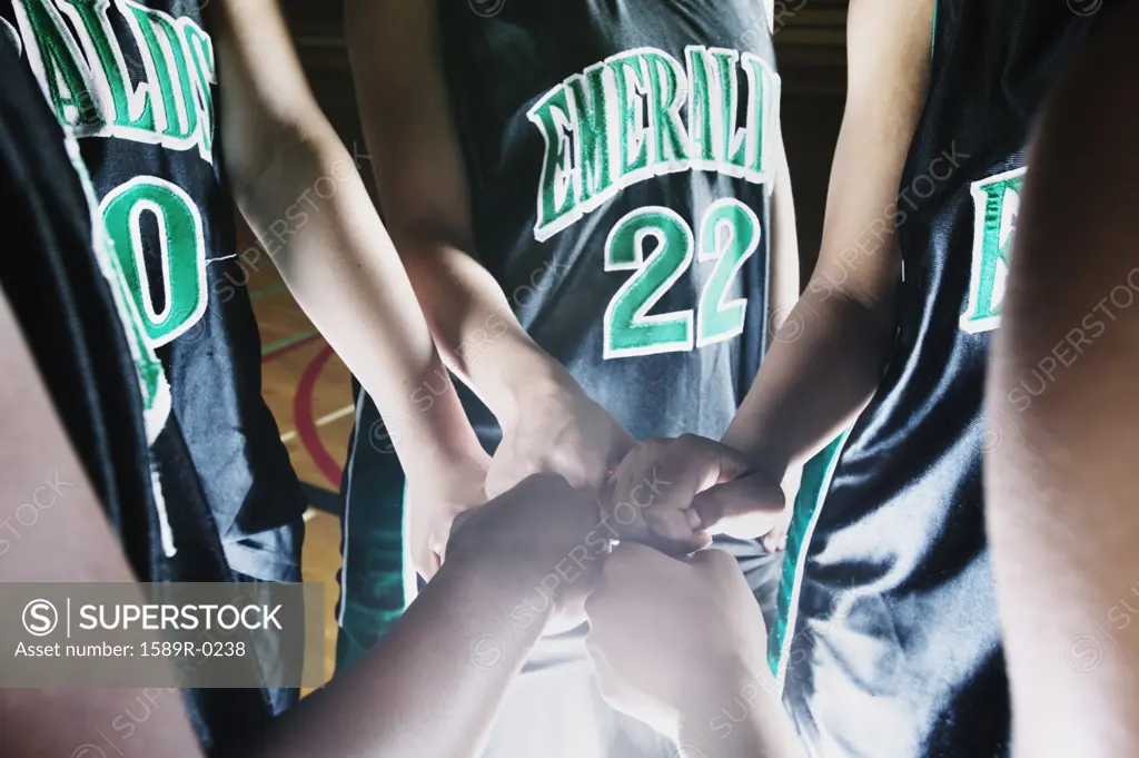 Female basketball team in a huddle on a basketball court