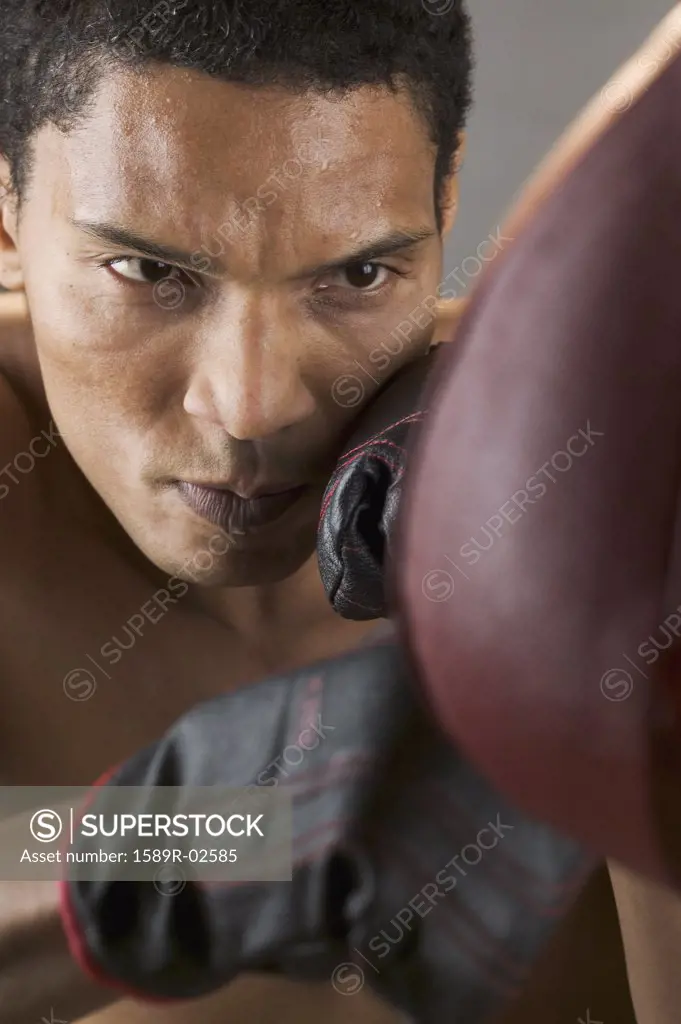 Close-up of a mid adult man punching a speed bag