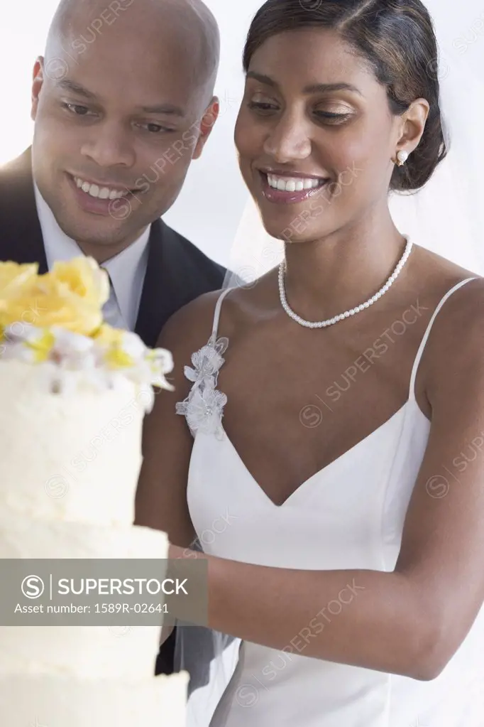 Bride and groom looking at their wedding cake