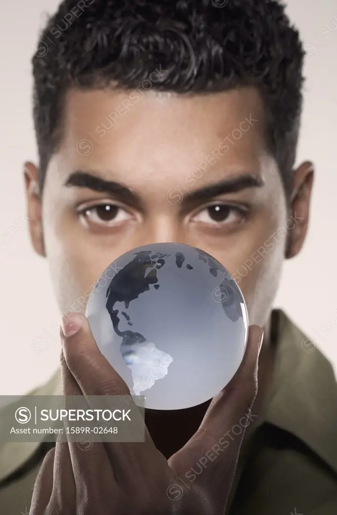 Young man holding a glass globe