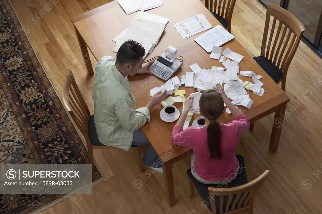High angle view of a young couple working out home finances