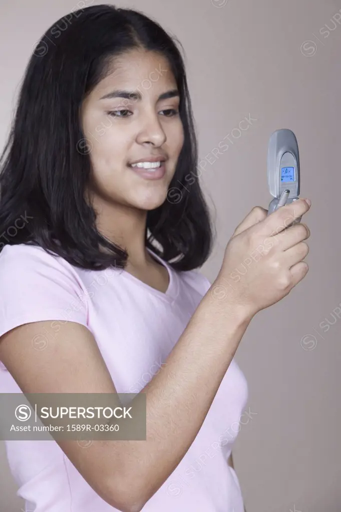 Side profile of a teenage girl holding a mobile phone
