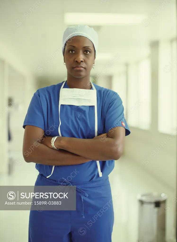Portrait of a female nurse wearing surgical scrubs standing in a hospital corridor