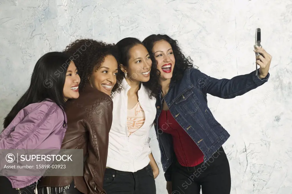 Group of young women smiling at a camera phone held in front of them