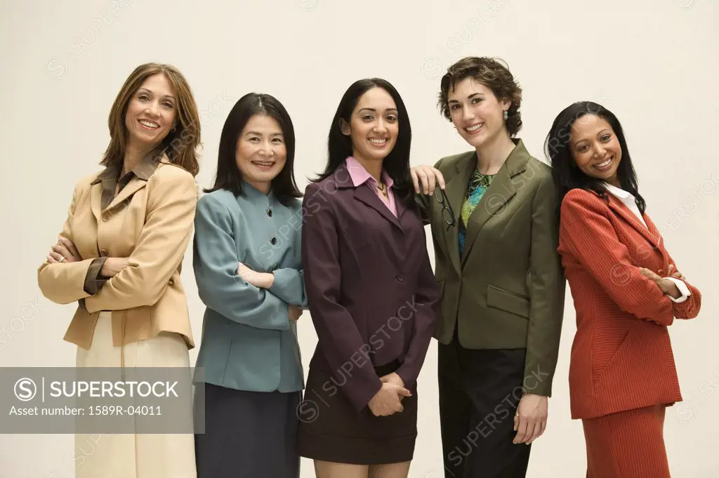 Group of young businesswomen standing together looking at camera smiling