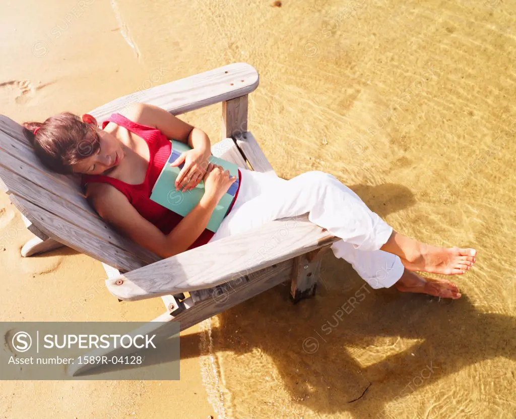 High angle view of a young woman sitting on a beach chair