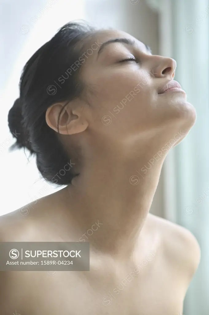 Young woman looking up with eyes closed