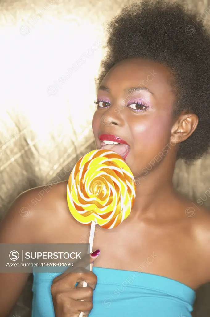 Portrait of a young woman licking a lolli pop