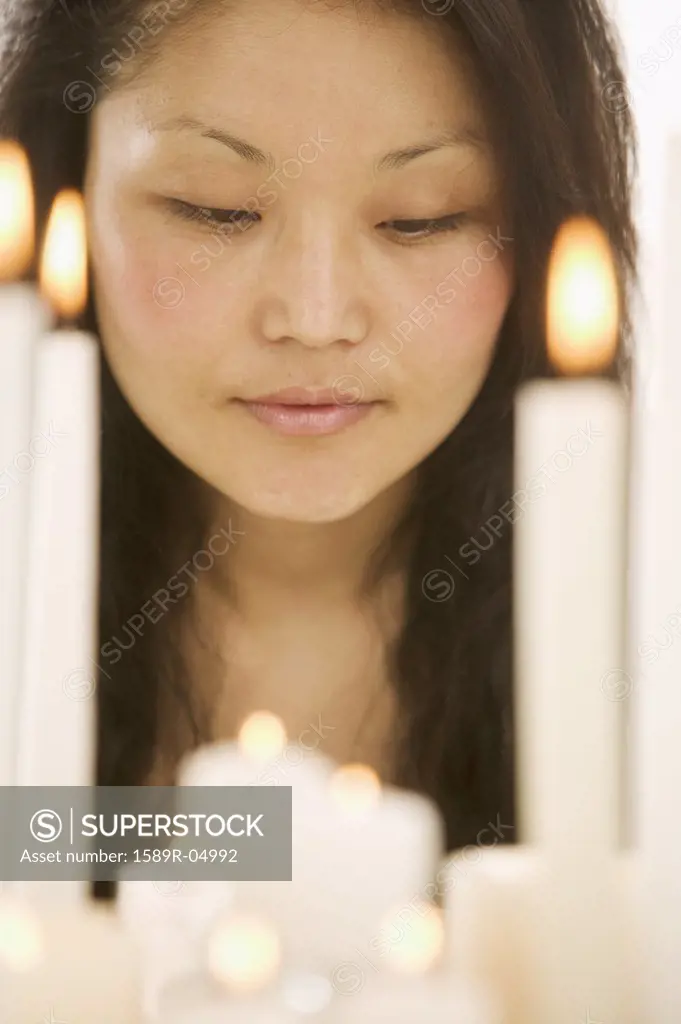 Woman looking at lit candles on a cake