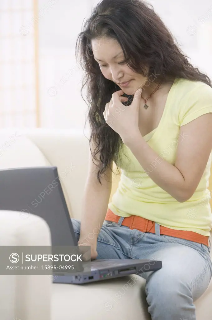 Woman sitting on a couch working on a laptop