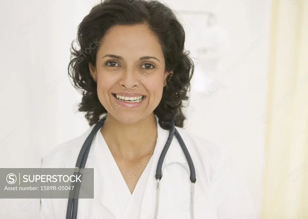 Portrait of a female doctor with a stethoscope around her neck looking at camera smiling