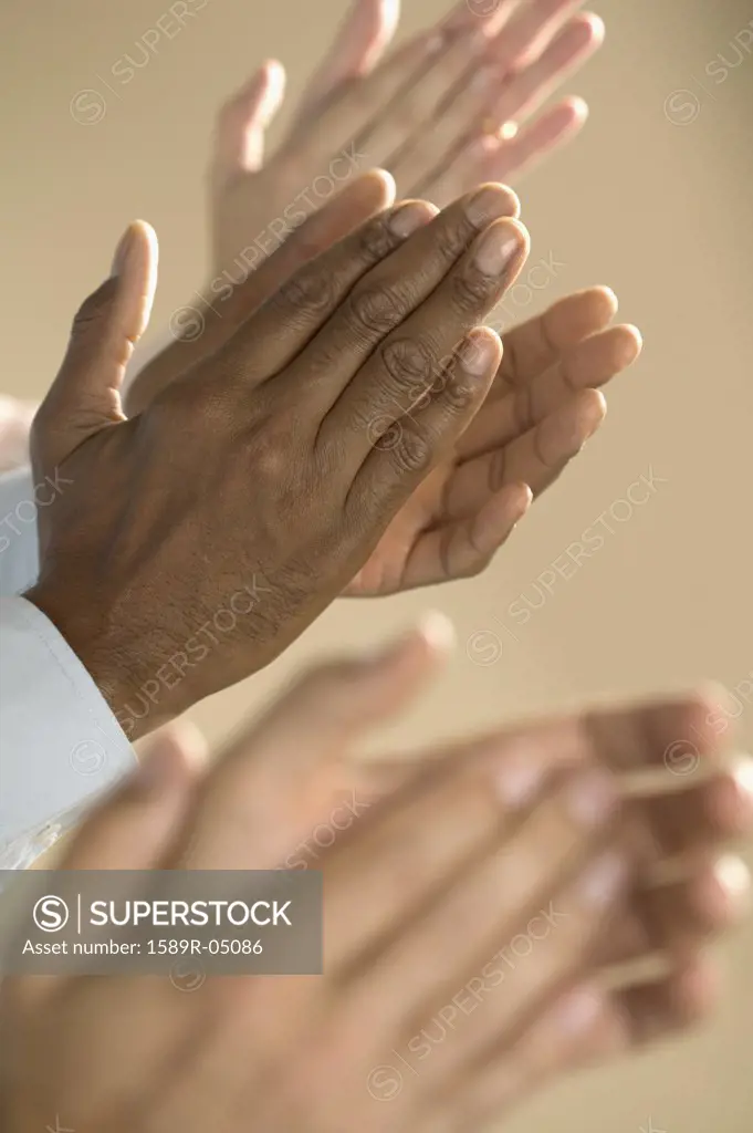 View of hand's of three people clapping