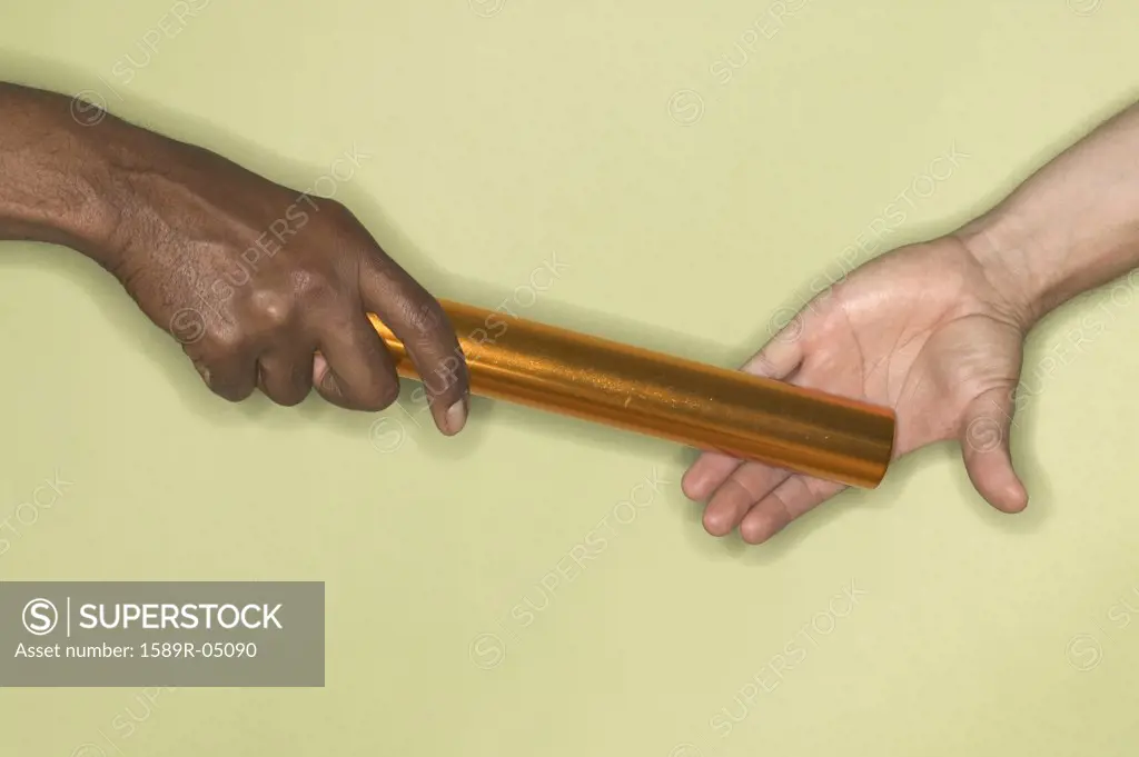 Persons hand passing a baton to another person