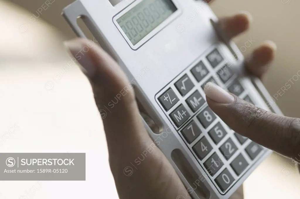 Person's hands operating a calculator