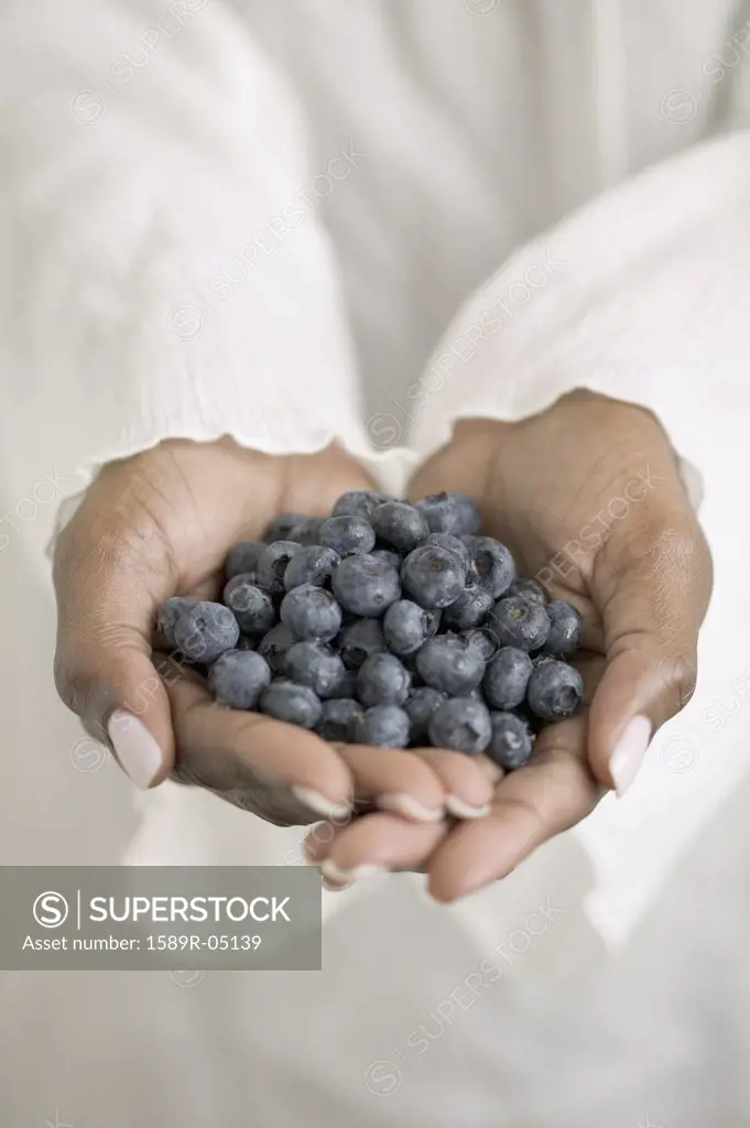 Woman's hands holding blueberries