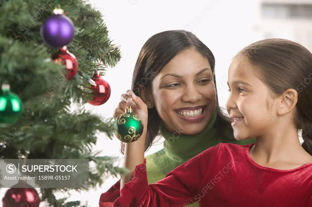 Mother and daughter decorating a Christmas tree