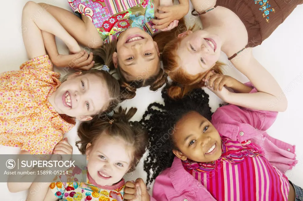 High angle view of a group of young girls lying down together smiling