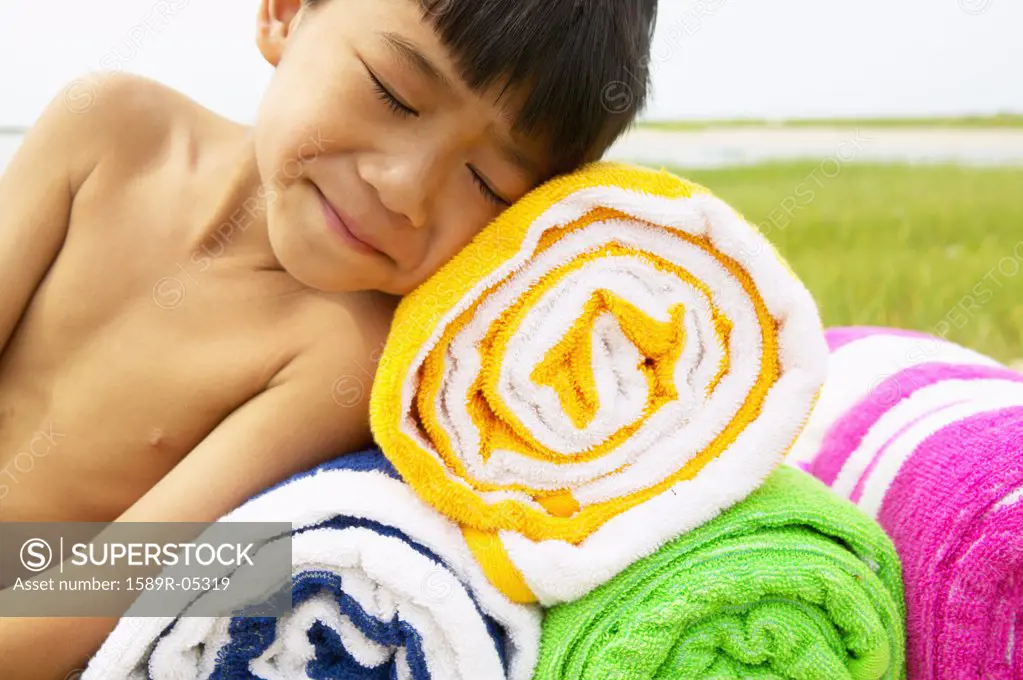 Young boy lying on towels