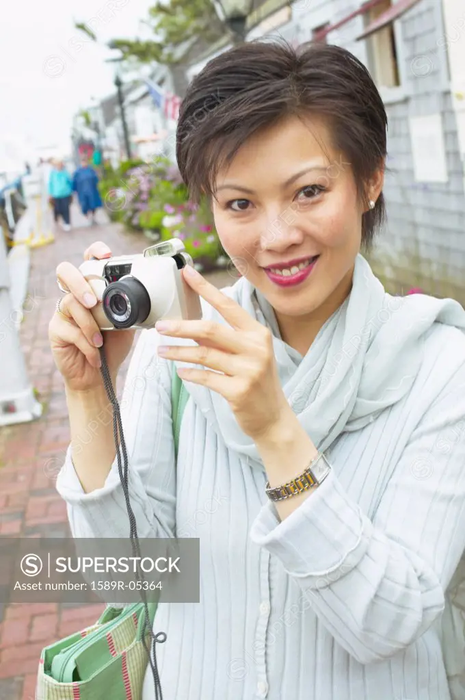 Portrait of a mid adult woman holding a camera