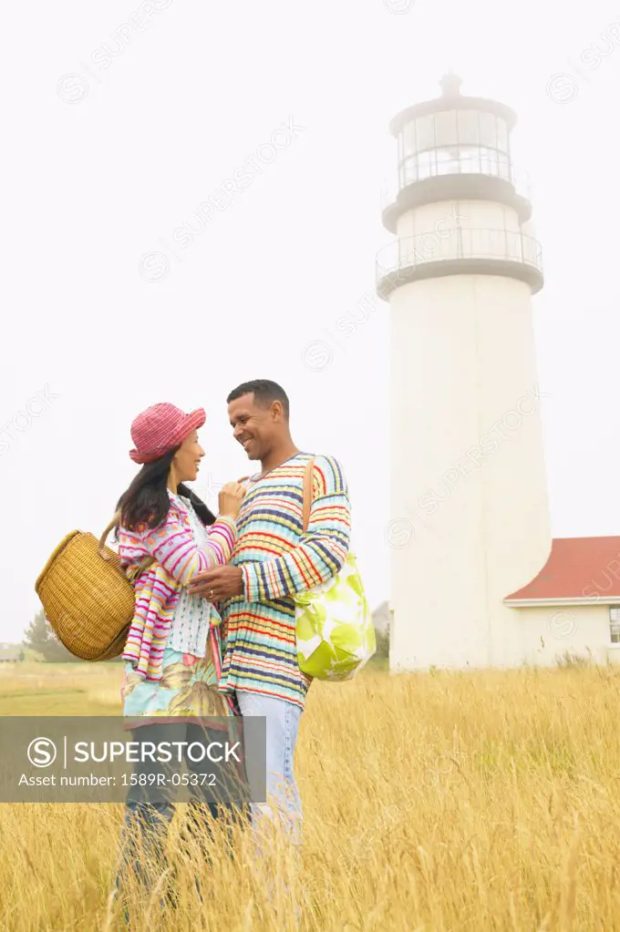 Couple standing in a field looking at each other