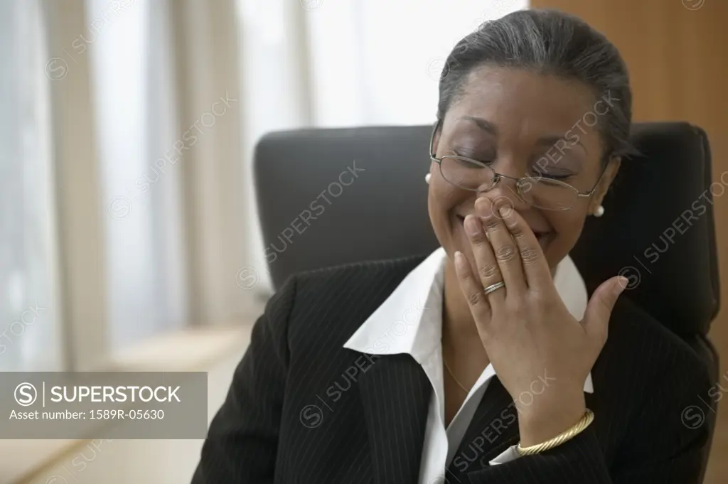 Businesswoman sitting at a desk with her hand on her face