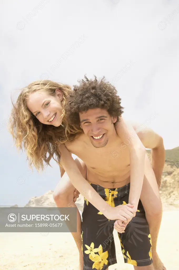 Portrait of teenage girl riding piggyback on a teenage boy