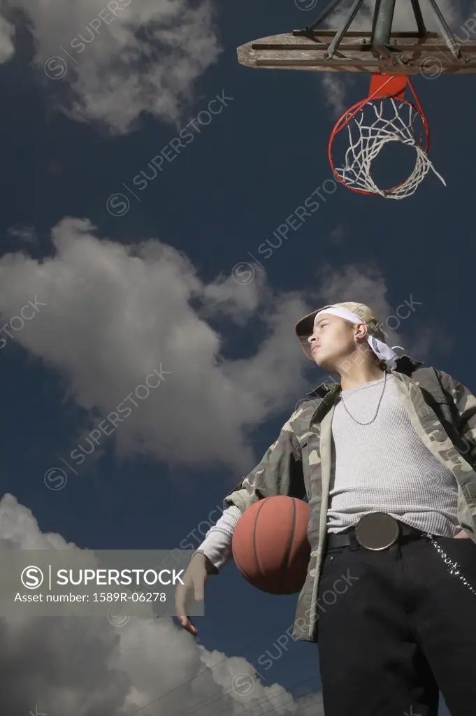 Low angle view of a young man holding a basketball