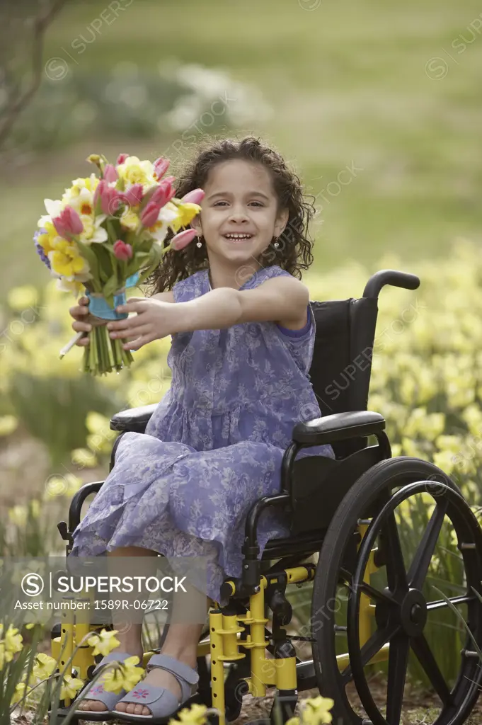 Portrait of a girl sitting on a wheelchair and holding a bouquet of flowers