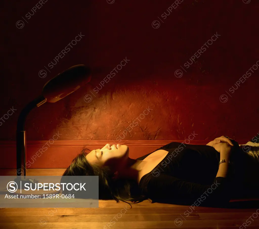 Side profile of a young woman lying on the floor