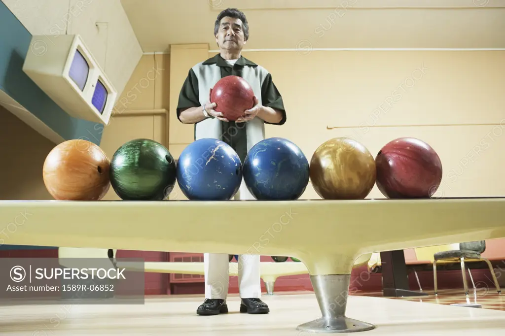 Portrait of a mature man holding a bowling ball