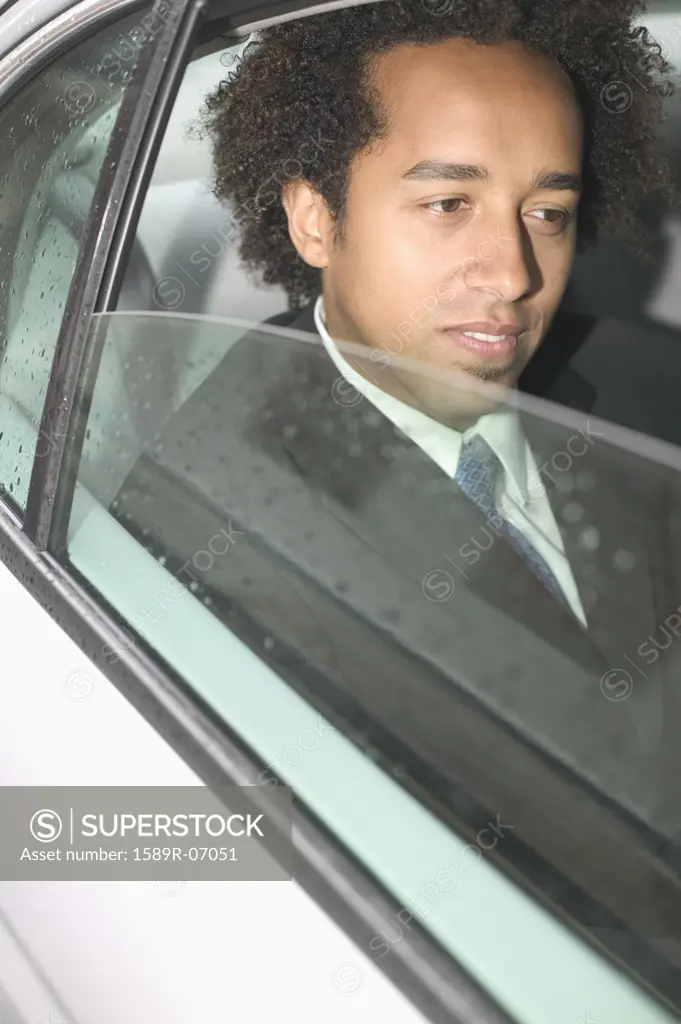 Mid adult businessman siting in a car