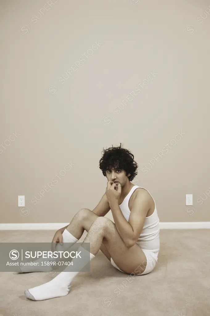 Portrait of a young man sitting on the floor