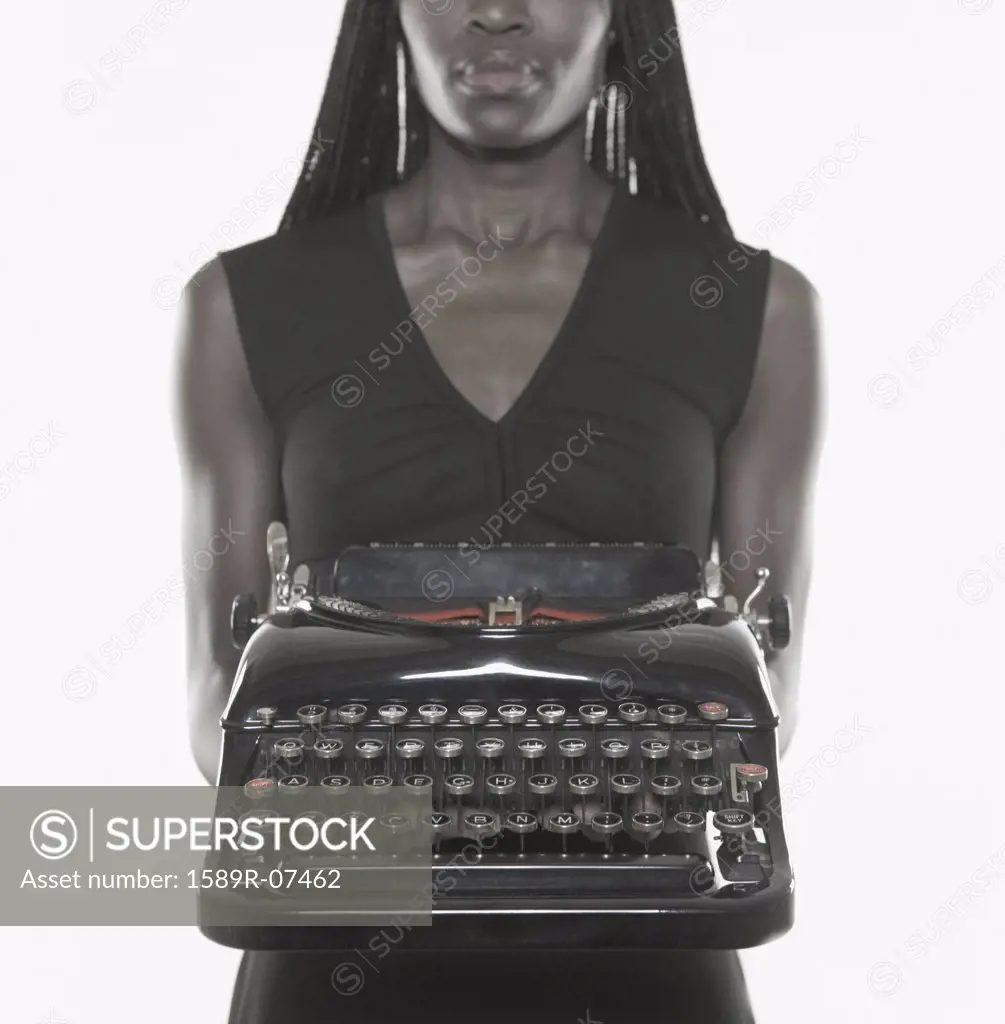 Mid adult woman holding a typewriter