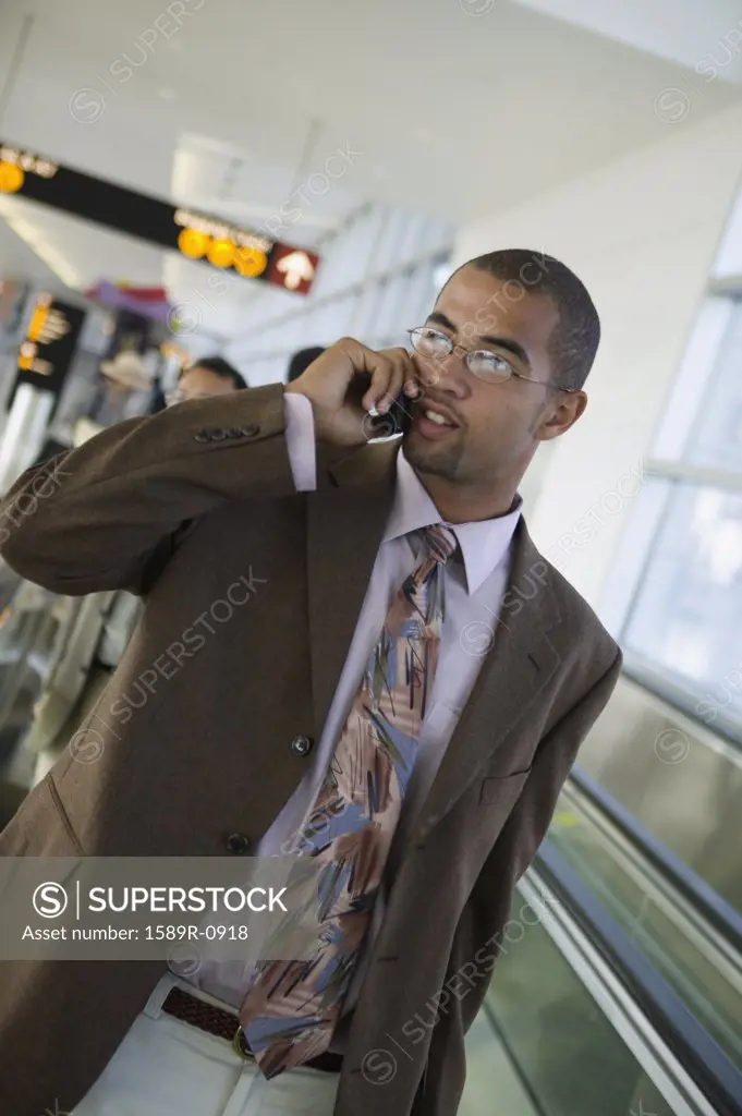 Young businessman talking on a mobile phone in an airport