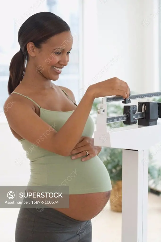 Pregnant African woman on scale
